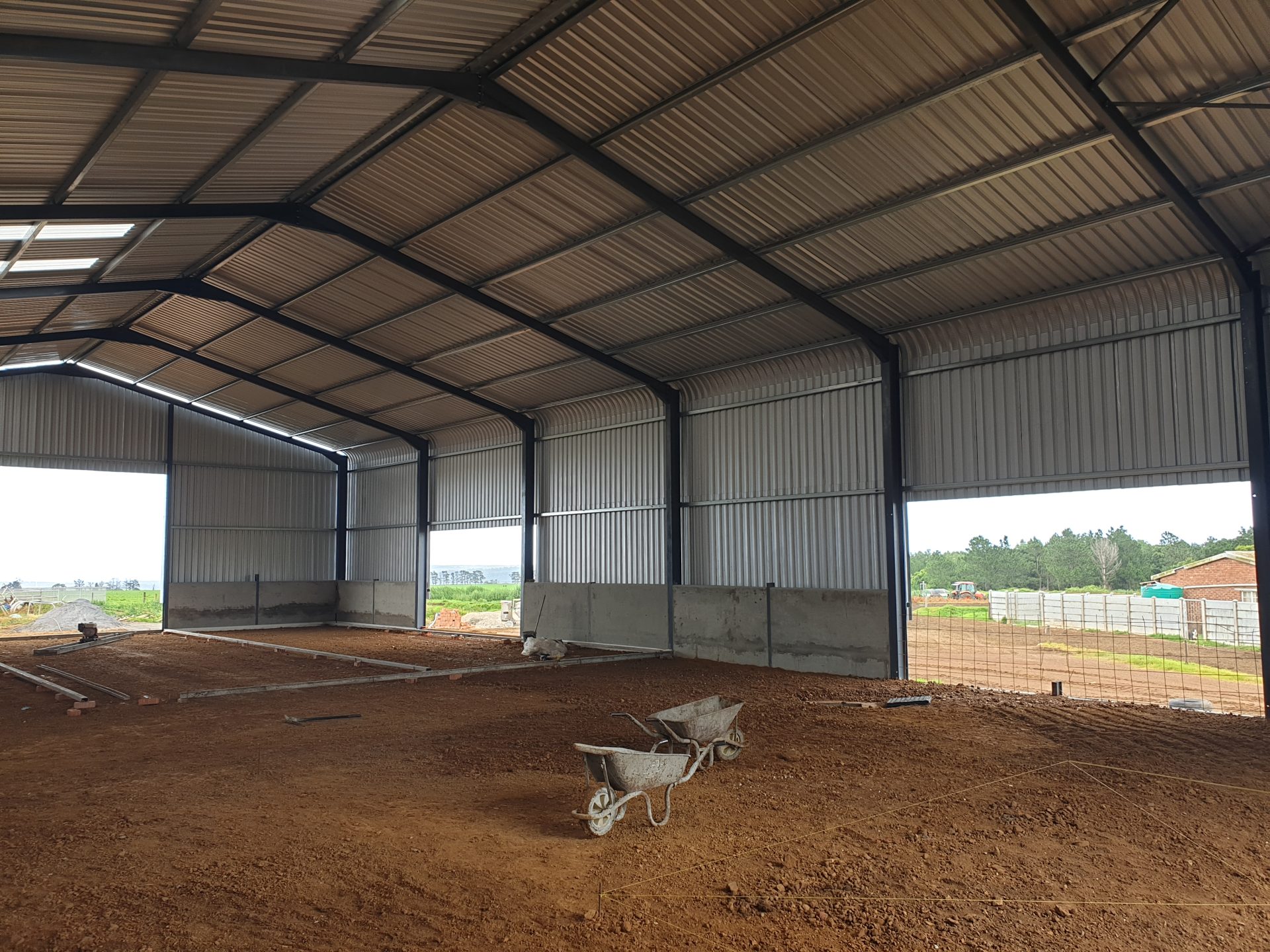 Prepping for concrete floor installation inside steel barn